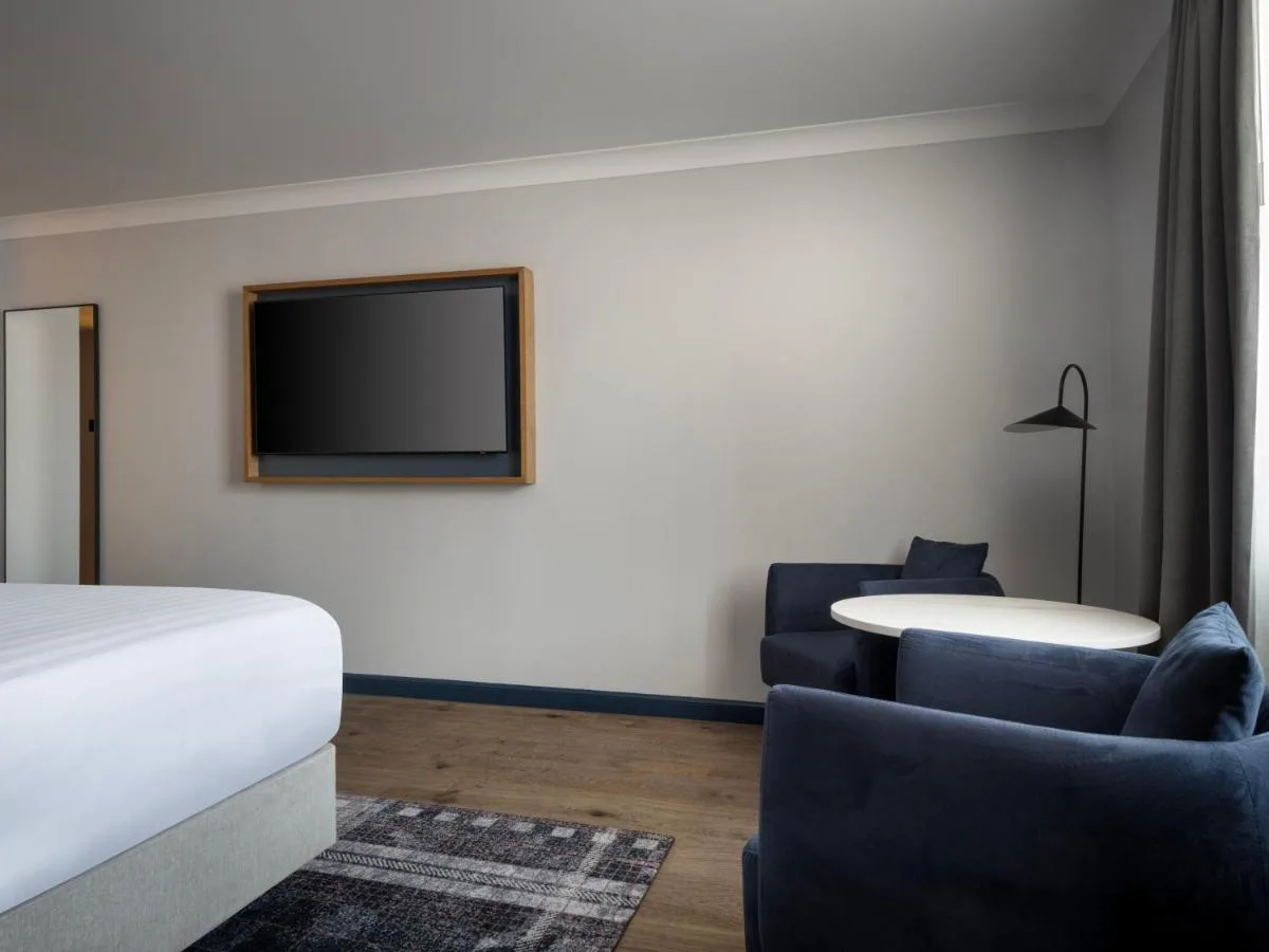 a hotel room with a bed and a tv at Edinburgh Marriott Hotel Holyrood in Edinburgh