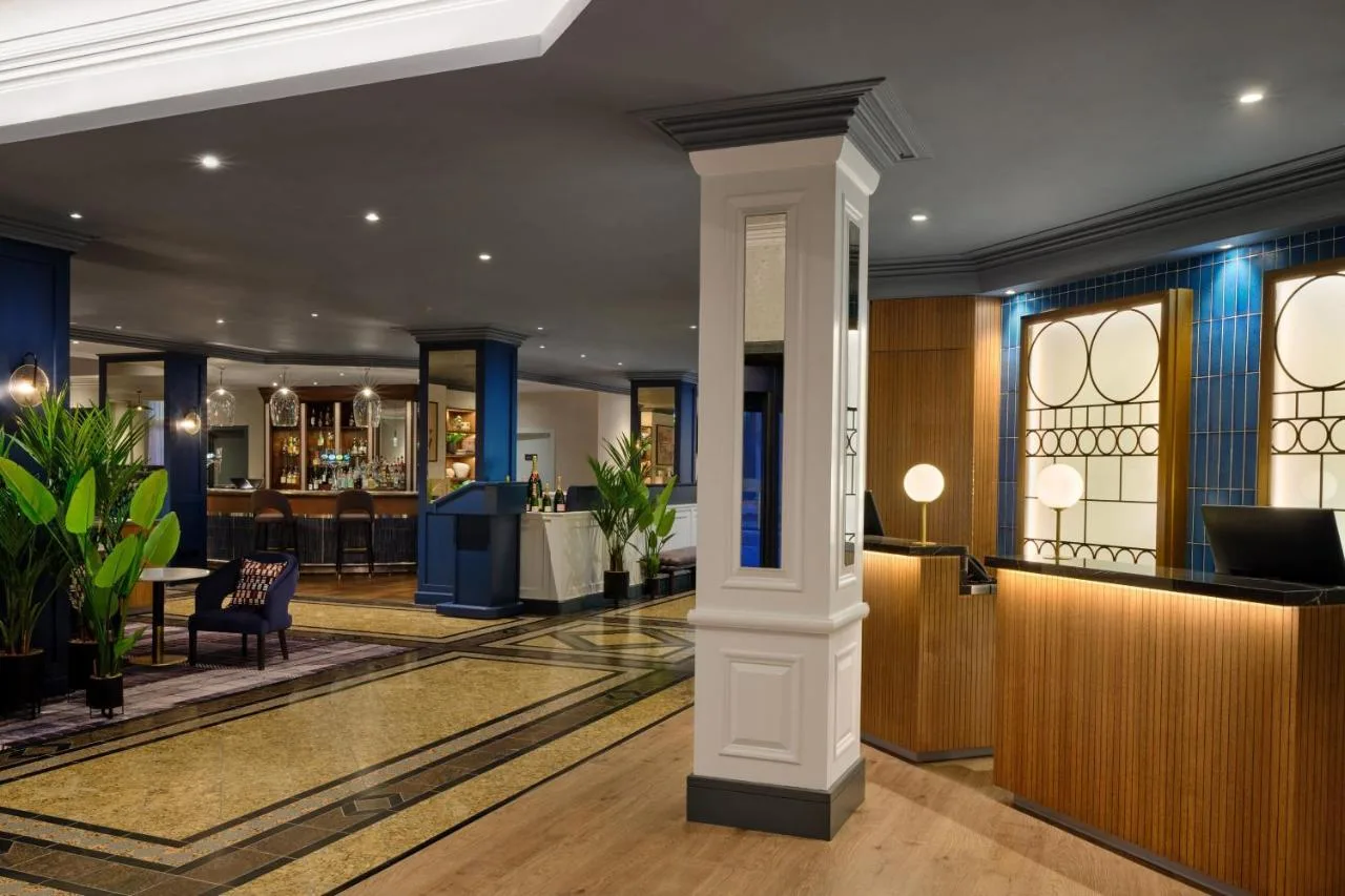 a lobby of a hotel with a table and chairs at Edinburgh Marriott Hotel Holyrood in Edinburgh