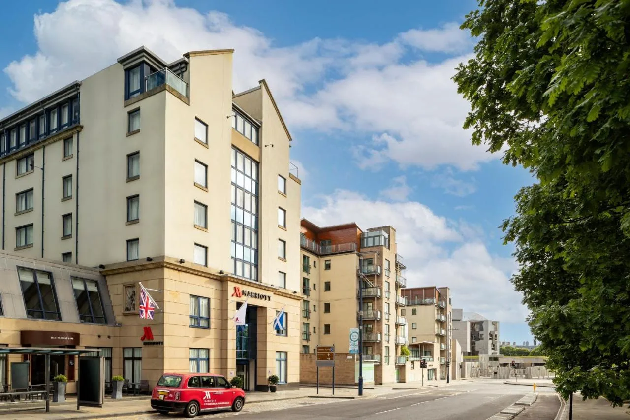 a red car parked in front of a building at Edinburgh Marriott Hotel Holyrood in Edinburgh